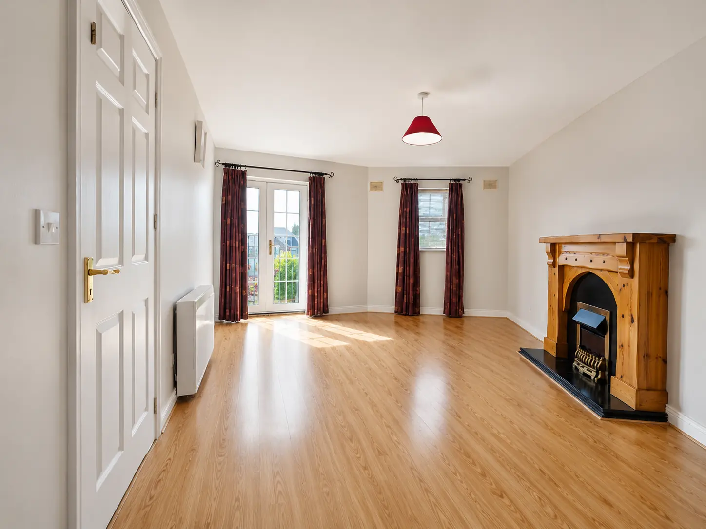 Open living space at 14 Dunamase with a timber floor, fireplace and glazed doors