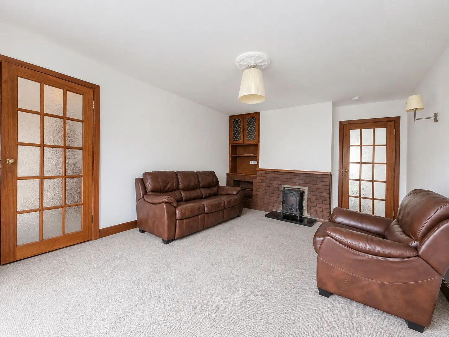 Living room at 104 Newpark with leather seating, a fireplace and natural window light